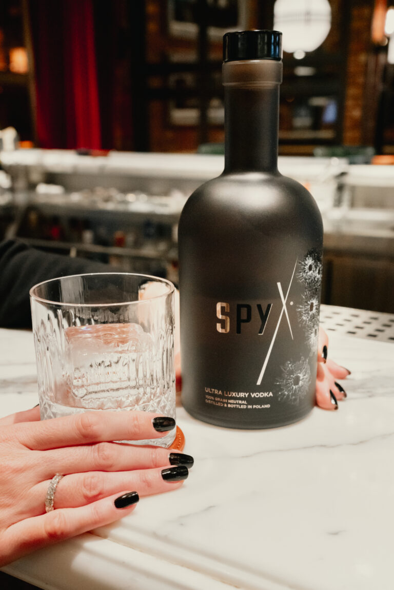 Spy X ultra-luxury vodka bottle with on-the-rocks glass highlighting its smooth sensory profile in a premium bar setting